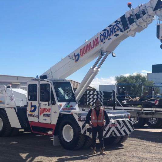 Smiling Trades-person Standing In Front Of Quinlan Rental Crane